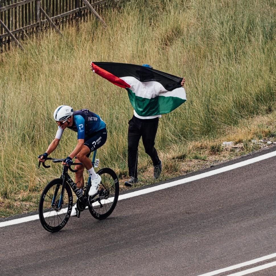 Israel-Premier Tech&rsquo;s Marco Frigo rides past spectator with Palestine flag, stage 7, 2025 Vuelta (cropped)